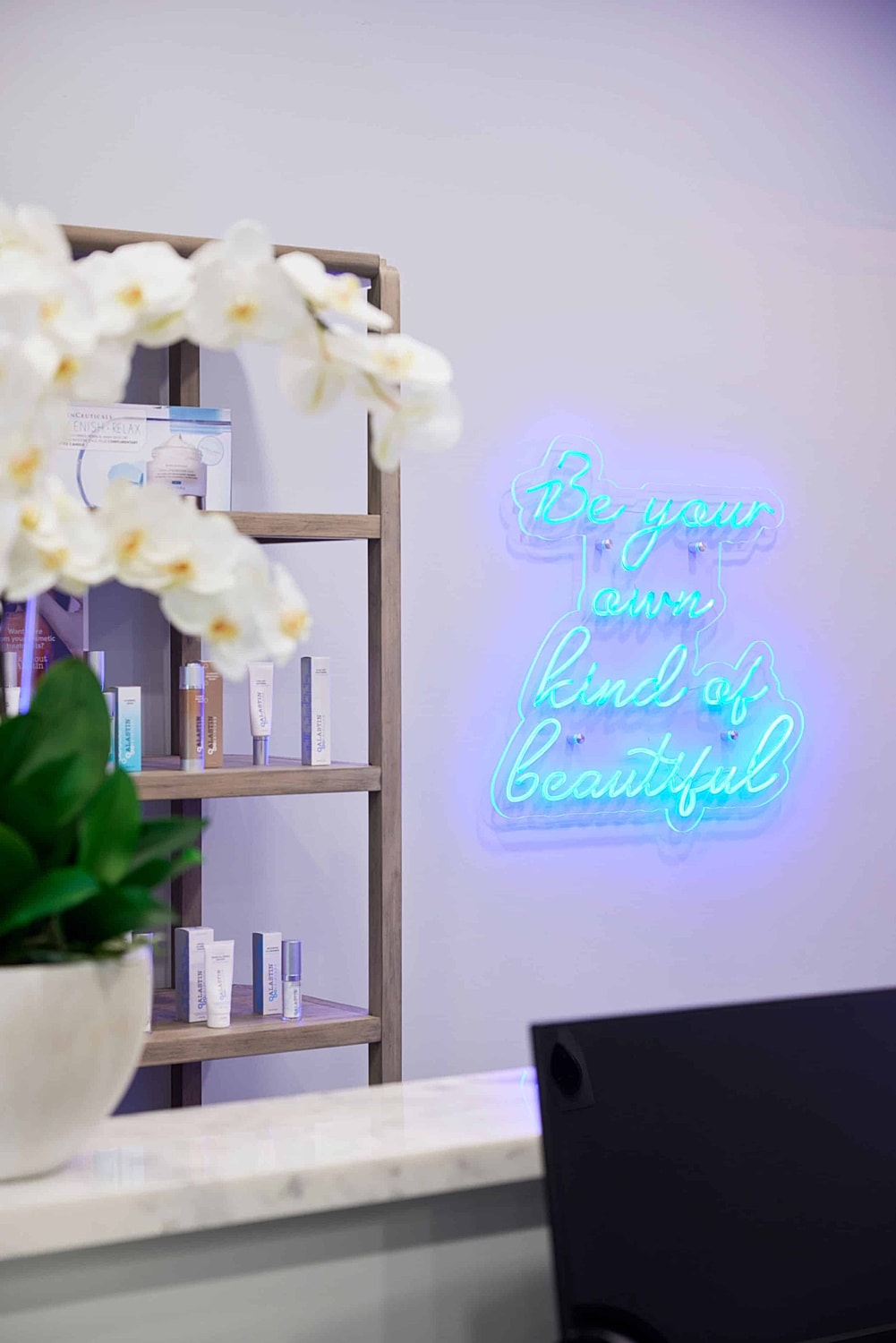 Neon sign with beauty products and flowers.