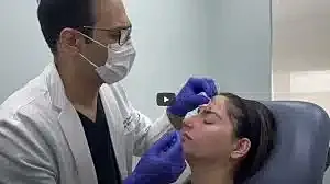 Medical professional administering facial treatment procedure.