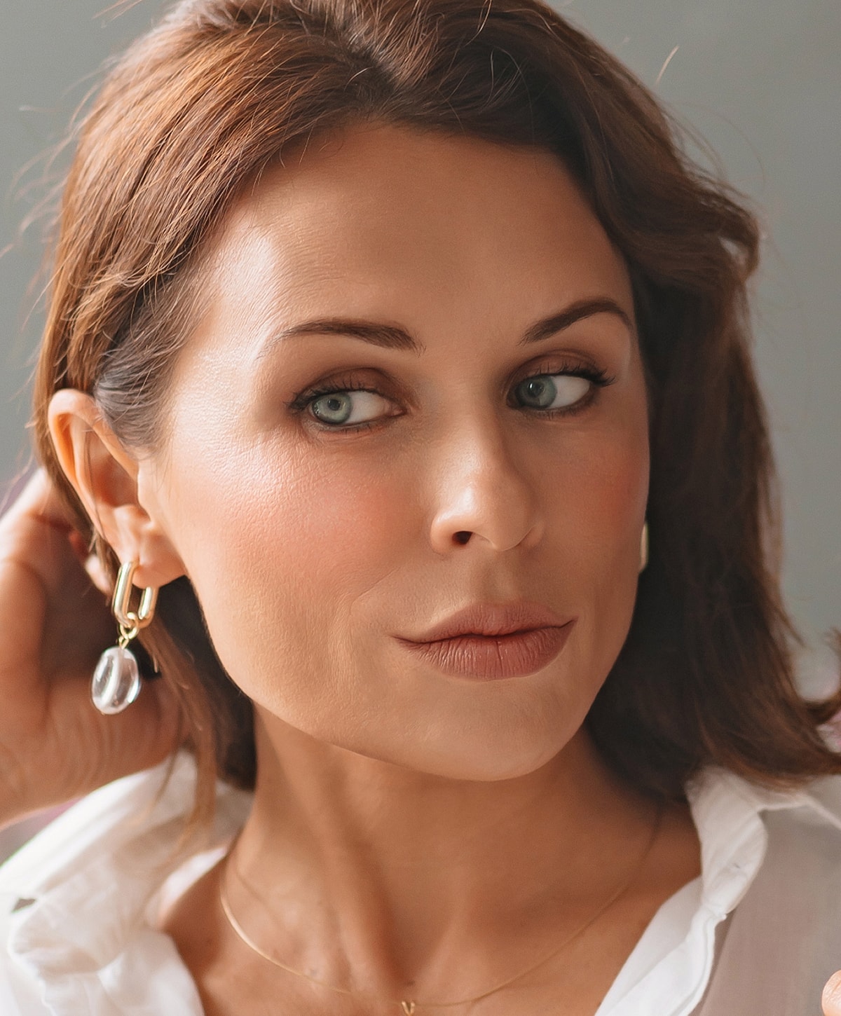 Woman with elegant hairstyle and white blouse.