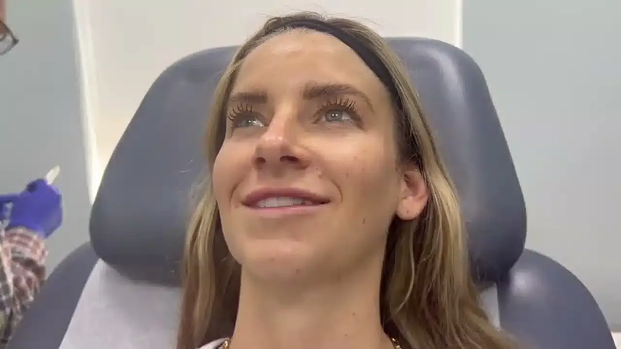 Woman smiling in a cosmetic treatment chair.