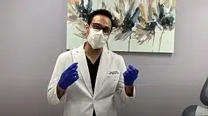 Healthcare professional in a mask and gloves.