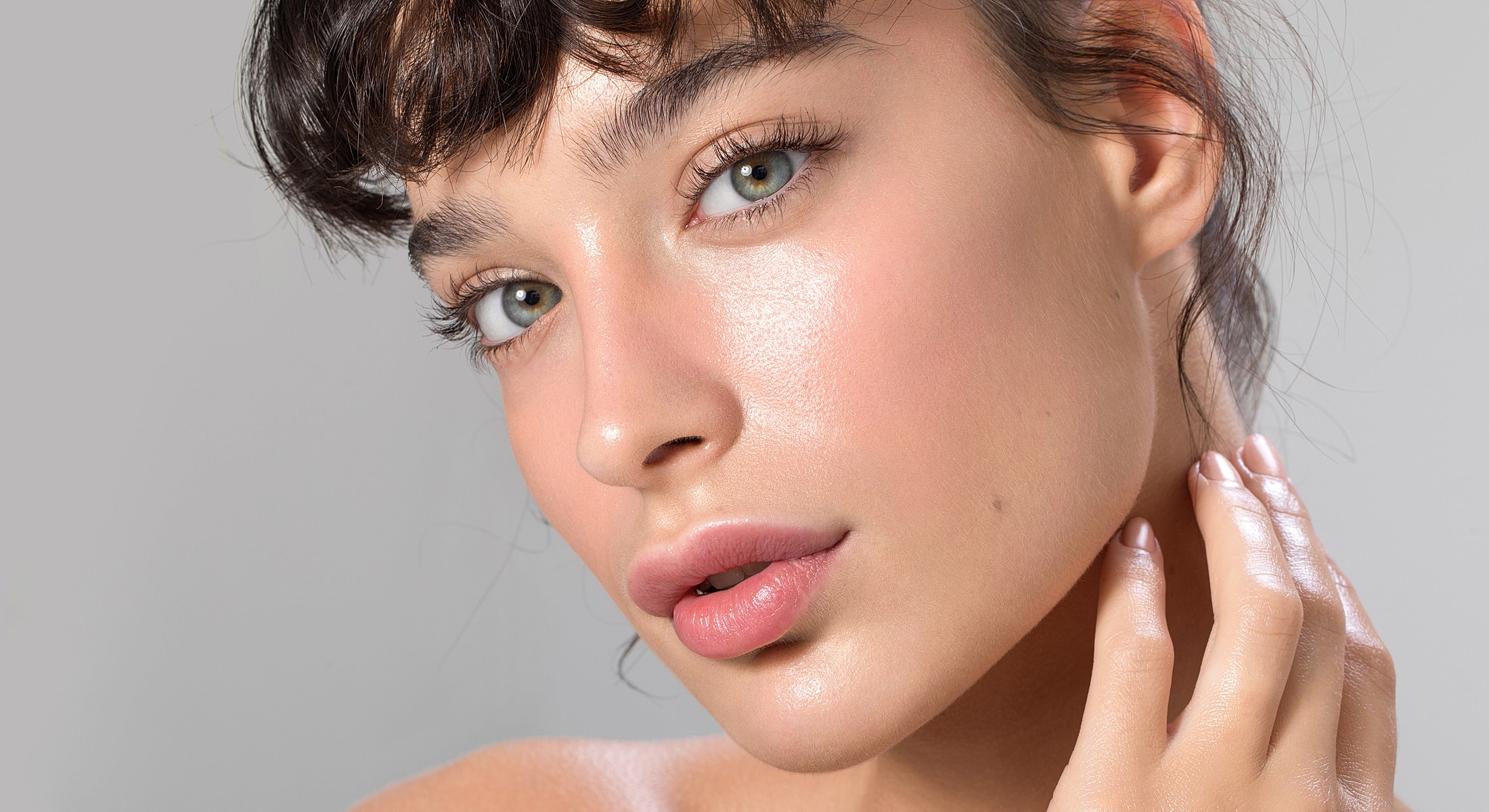 Close-up of person with glowing skin and makeup.