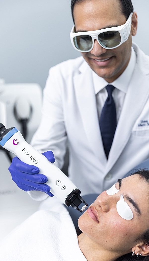 Medical professional performing facial treatment on patient.